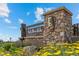 Stone community center sign with lush greenery and blue skies create inviting entrance at 11961 S Saunter Ln, Parker, CO 80138