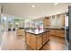 Open-concept kitchen with a spacious island, wood cabinetry, and sleek black countertops at 11961 S Saunter Ln, Parker, CO 80138