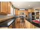 Efficient kitchen featuring stainless appliances, dark countertops and plentiful storage in wood cabinetry at 11961 S Saunter Ln, Parker, CO 80138