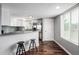 Modern kitchen features white cabinets, stainless steel appliances, breakfast bar, and hardwood floors at 5250 S Huron Way # 13-312, Littleton, CO 80120