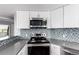 The updated kitchen has stainless steel appliances, lots of cabinets and granite counter tops at 5250 S Huron Way # 13-312, Littleton, CO 80120