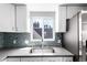 The kitchen features stainless steel appliances, a tile backsplash and plenty of natural light at 5250 S Huron Way # 13-312, Littleton, CO 80120