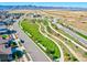 An aerial view highlights the community's green spaces, with pathways, road access, and a view of distant mountains at 8056 Piney River Ave, Littleton, CO 80125