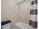 Cozy bathroom featuring a tub and shower combination with stylish tile and a striped curtain at 8056 Piney River Ave, Littleton, CO 80125