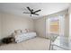 Bedroom includes ceiling fan, full bed, desk with chair, and large window at 8056 Piney River Ave, Littleton, CO 80125