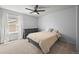 Bright bedroom features neutral walls, carpet, ceiling fan, and window with natural light at 8056 Piney River Ave, Littleton, CO 80125