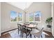 Bright dining room with large windows, vaulted ceilings, an oval table, and modern lighting at 8056 Piney River Ave, Littleton, CO 80125