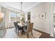 Cozy dining room with a rustic wooden table, modern chandelier, and natural light from large windows at 8056 Piney River Ave, Littleton, CO 80125