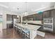 Modern kitchen with large island, stainless steel appliances, dark cabinets, and granite countertops at 8056 Piney River Ave, Littleton, CO 80125