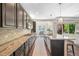 Spacious kitchen with island seating, stainless steel appliances, granite countertops, and dark wood cabinets at 8056 Piney River Ave, Littleton, CO 80125