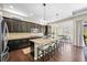 Open kitchen features a large island with seating, dark cabinetry, granite counters and stainless appliances at 8056 Piney River Ave, Littleton, CO 80125