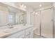 A modern bathroom with double sinks, large mirror, and glass-enclosed shower at 13458 E 111Th Ave, Commerce City, CO 80022