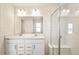 A modern bathroom with double sinks, large mirror, and glass-enclosed shower at 13458 E 111Th Ave, Commerce City, CO 80022