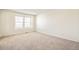 A bright bedroom features neutral carpet, white walls, and two sunny windows at 13458 E 111Th Ave, Commerce City, CO 80022