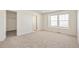 A bright bedroom features neutral carpet, white walls, a walk-in closet, and a window at 13458 E 111Th Ave, Commerce City, CO 80022