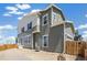A side view of a two-story home featuring green siding, white trim and a fenced in yard at 13458 E 111Th Ave, Commerce City, CO 80022