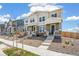 Two-story townhomes featuring stone accents, covered porches, and manicured landscaping at 13458 E 111Th Ave, Commerce City, CO 80022