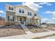 Two-story townhomes featuring stone accents, covered porches, and a sidewalk at 13458 E 111Th Ave, Commerce City, CO 80022