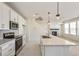 Well-lit kitchen features stainless steel appliances, tile backsplash, a marble countertop island, and a cozy fireplace at 13458 E 111Th Ave, Commerce City, CO 80022