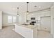 Well-lit kitchen with white cabinets, stainless appliances, and a central island with overhead pendant lights at 13458 E 111Th Ave, Commerce City, CO 80022
