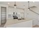 Modern kitchen boasts white cabinetry, gray backsplash, stainless appliances, and island with pendant lighting at 13458 E 111Th Ave, Commerce City, CO 80022