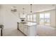 Open-concept living room with fireplace and kitchen island, bathed in natural light through large windows at 13458 E 111Th Ave, Commerce City, CO 80022