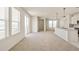 Spacious living area with large windows, plush carpeting, and a seamless transition to the modern kitchen at 13458 E 111Th Ave, Commerce City, CO 80022