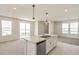 Spacious open-plan kitchen and living space with island, deck access, and neutral decor at 13458 E 111Th Ave, Commerce City, CO 80022