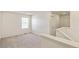 A bright loft space with neutral carpet, white walls, a window, and access to upstairs at 13458 E 111Th Ave, Commerce City, CO 80022