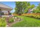 Manicured backyard with fresh green grass, a flowerbed and a wooden fence at 7465 S Ivy Way, Centennial, CO 80112