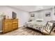 Bright bedroom featuring a dresser, TV, neutral paint, and modern flooring at 7465 S Ivy Way, Centennial, CO 80112