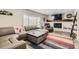Cozy living room featuring a comfortable leather sofa, fireplace, and ample natural light for relaxation and entertainment at 7465 S Ivy Way, Centennial, CO 80112