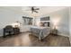 Bright bedroom featuring a patterned bedspread, ceiling fan, wood-look flooring and a window at 8348 W 90Th Ave, Broomfield, CO 80021