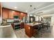 Spacious kitchen featuring wooden cabinetry, an island with seating and stainless steel appliances at 8348 W 90Th Ave, Broomfield, CO 80021