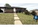 Brick home with manicured front yard, sidewalk, porch, and sign for listing agent at 9486 Pelon Dr, Denver, CO 80260