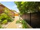 Charming backyard featuring a gravel path, dark wooden fence, and mature landscaping at 306 E Iowa Ave, Berthoud, CO 80513