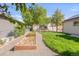 Spacious backyard featuring a garden area, storage shed, lush green grass and mature trees at 306 E Iowa Ave, Berthoud, CO 80513