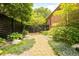 Beautiful backyard with gravel path, lush greenery, and a stylish dark wooden fence at 306 E Iowa Ave, Berthoud, CO 80513