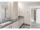 Elegant bathroom with double sinks, gray countertops, and tiled flooring at 306 E Iowa Ave, Berthoud, CO 80513