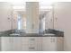 Bright bathroom features double sinks with vanity, large mirrors, and modern lighting at 306 E Iowa Ave, Berthoud, CO 80513