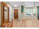 Bright and airy entryway with hardwood floors, coat rack and skylight, creating a welcoming ambiance into the home at 306 E Iowa Ave, Berthoud, CO 80513