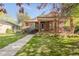 Charming brick home featuring a covered front porch with lovely landscaping and healthy green lawn at 306 E Iowa Ave, Berthoud, CO 80513