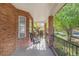 Inviting front porch with brick columns and black iron railing, providing a relaxing outdoor seating area and great views at 306 E Iowa Ave, Berthoud, CO 80513