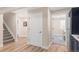 Bright hallway with wood-look floors, white trim and doors leads to stairs and additional rooms at 306 E Iowa Ave, Berthoud, CO 80513