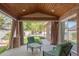 Covered patio with wood ceiling, brick pillars, curtains, and outdoor seating area at 306 E Iowa Ave, Berthoud, CO 80513