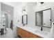 Bright bathroom featuring a double vanity, wood cabinets, and modern fixtures at 1035 S Josephine St, Denver, CO 80209