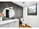 Stylish bathroom features a large round mirror, modern vanity, and elegant tiling at 1035 S Josephine St, Denver, CO 80209