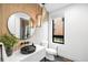 Modern powder room with black vessel sink, round mirror, and stylish pendant lighting at 1035 S Josephine St, Denver, CO 80209