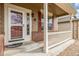 Inviting front porch featuring brick accents, white railings, and a decorative storm door, enhancing curb appeal at 1335 Galactic Pl, Castle Rock, CO 80108