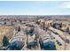 Aerial view of condos with mature trees, pool, and ample parking within a well maintained community at 8335 Fairmount Dr # 4-102, Denver, CO 80247